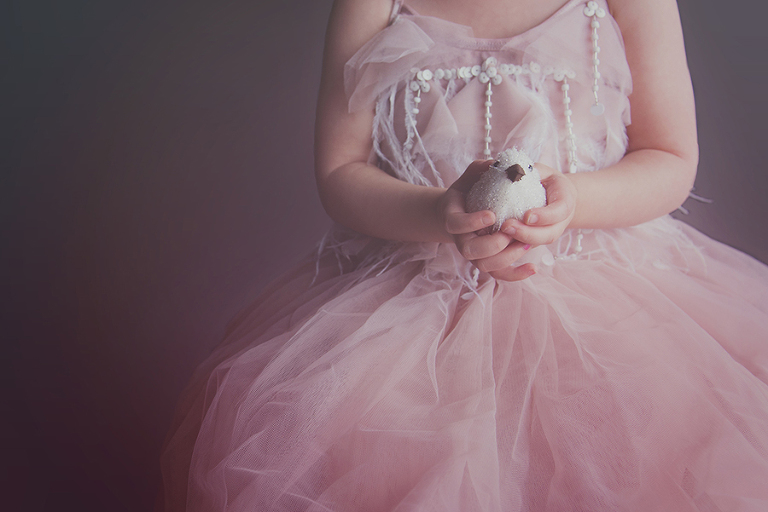 Image of little girl in pink dress holding dove