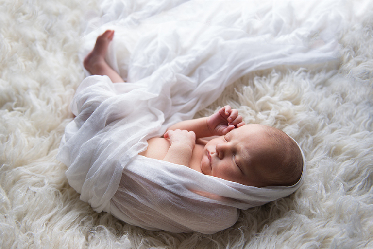 A newborn wrapped and sleeping peacefully