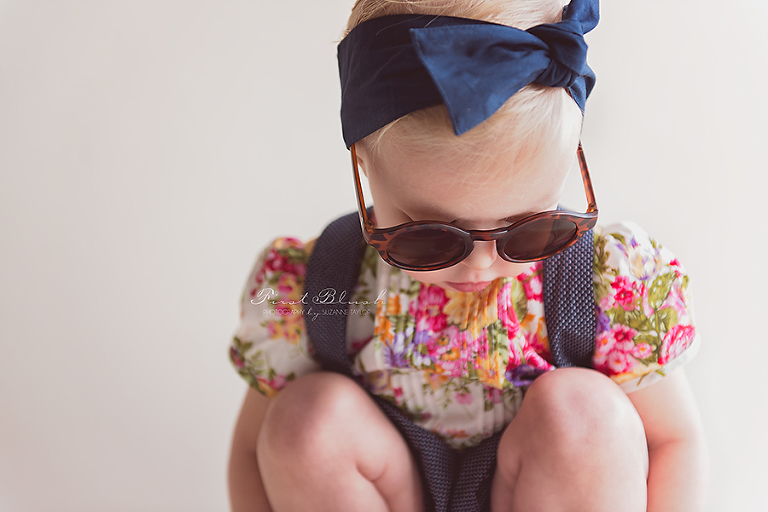 Toddler girl with sunglasses looking at the floor