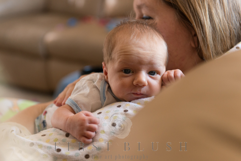 Small newborn boy staring at the camera