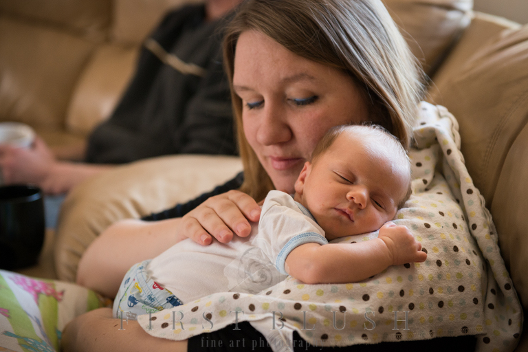 A newborn baby boy resting on his mothers shoulder