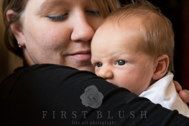 A newborn baby boy looks out a window