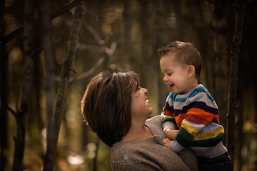 Mom holds son and both laugh