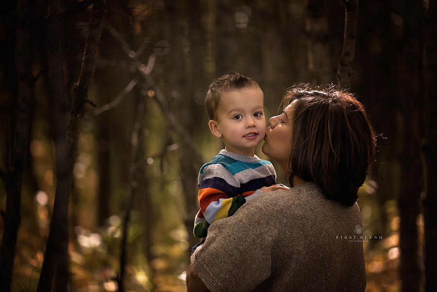 Mom holding son kissing him on the cheek