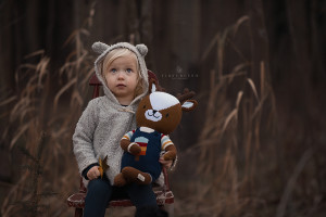 A young girl suffering from hunger and her stuffed animal both are looking up to the sky