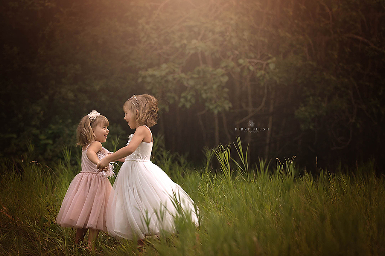 Sisters dancing in the grass near Bentley, AB.