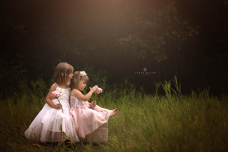 Big sister kisses little sister on the head near Bentley, AB