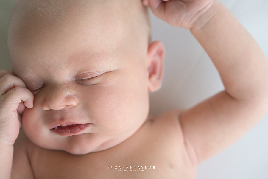 One newborn twin from Fort McMurray stretches with a closeup of his face.